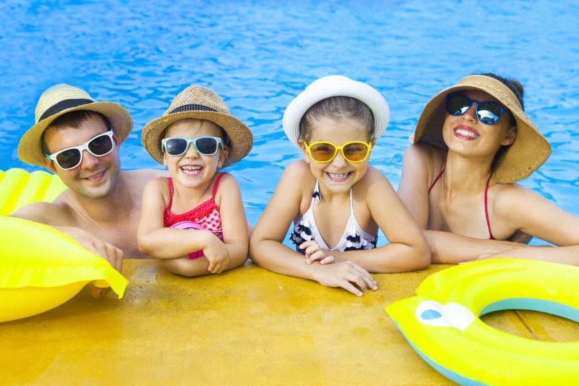 Happy family with two kids having fun in swimming pool