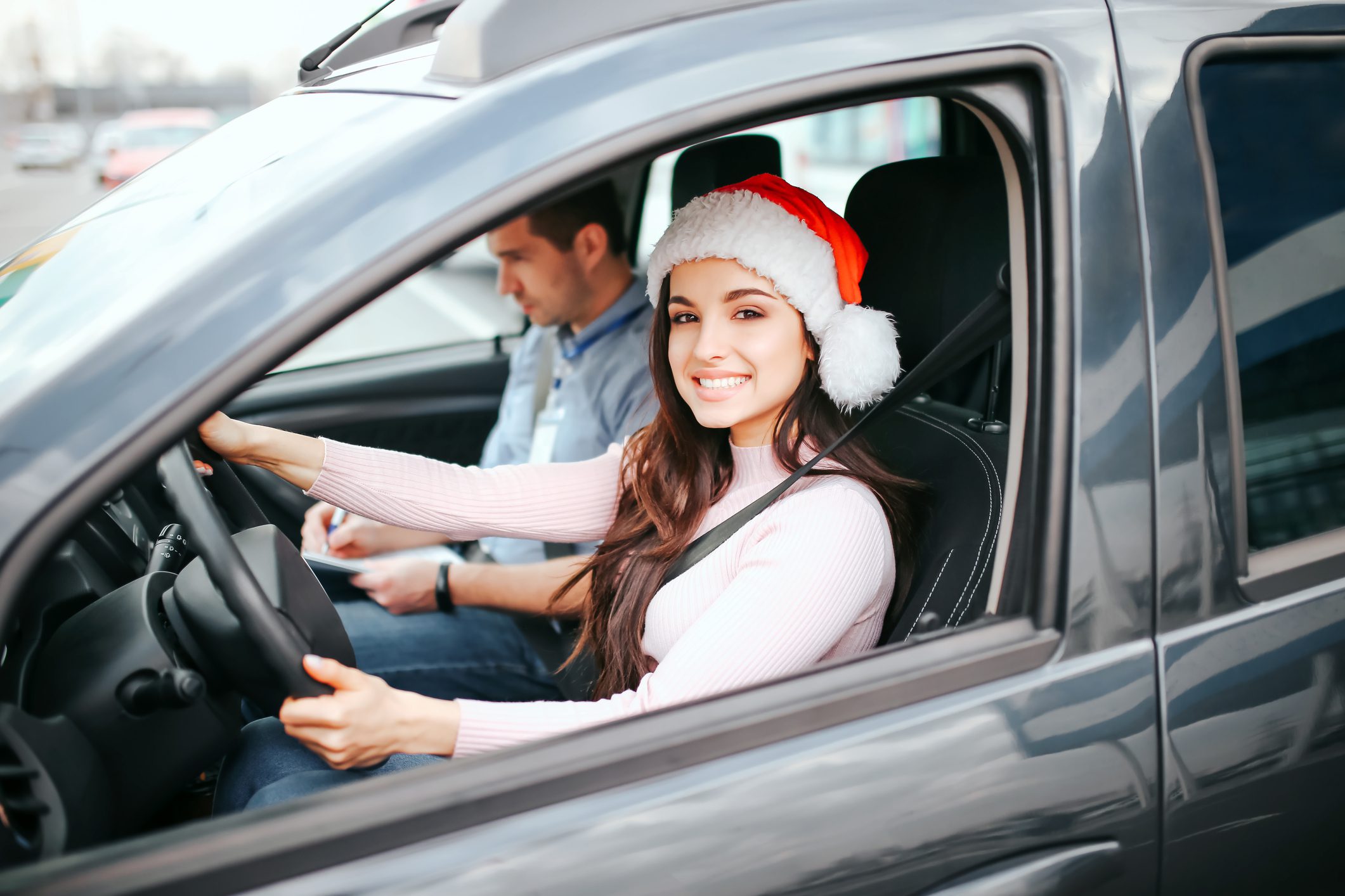 Woman in car with Santa hat, gifting extended service contract