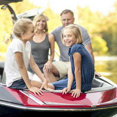 Beautiful young family sits in their ski boat ready to go skiing
