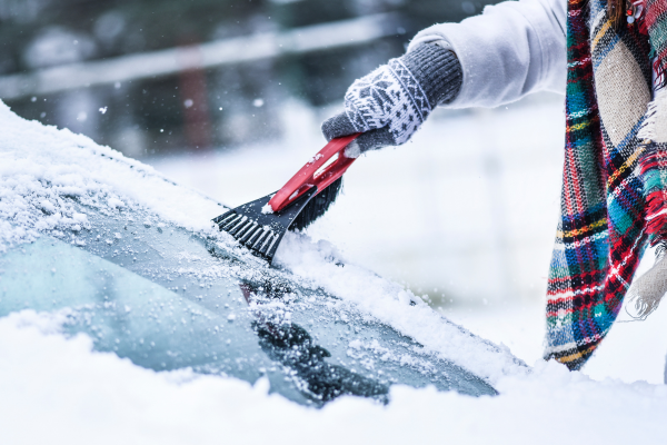 person-in-gloves-scraping-windshield